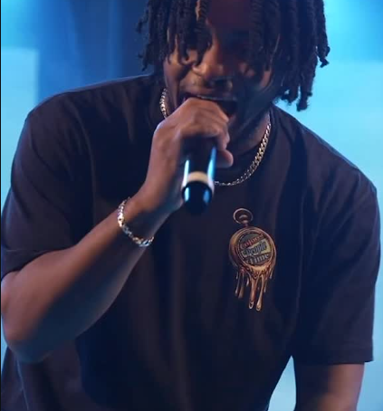 A performer holding a microphone under blue lights at a Beyond The Stage event